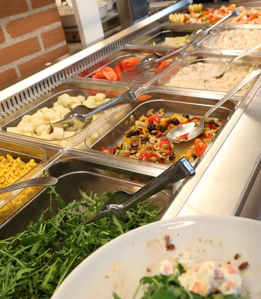 Inside a self service restaurant with many raw and cooked foods