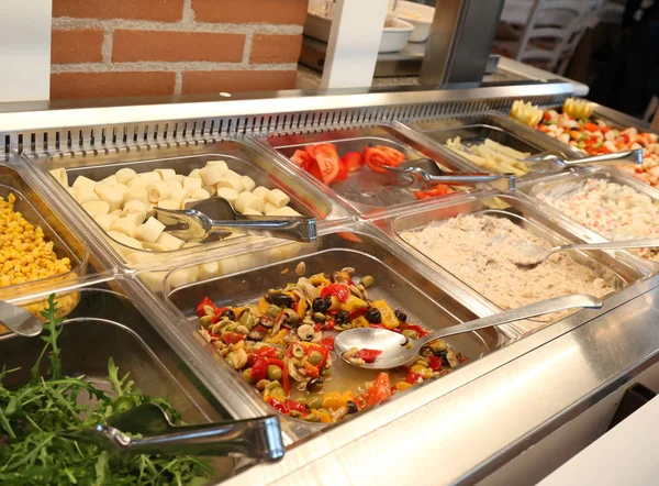 Inside a self service restaurant with many raw and cooked foods