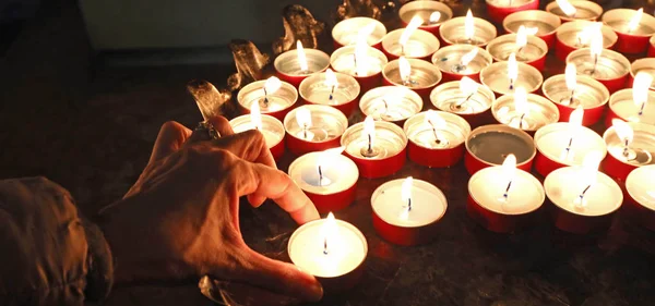 Hand Van Oude Weduwe Die Met Vele Brandende Kaarsen Plaats — Stockfoto