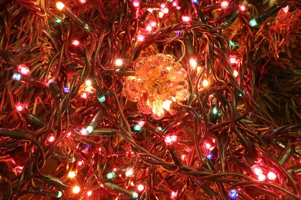 Χριστουγεννιάτικο Φόντο Χρυσό Κουκουνάρι Και Χρωματιστά Φώτα Του Χριστουγεννιάτικου Δέντρου — Φωτογραφία Αρχείου