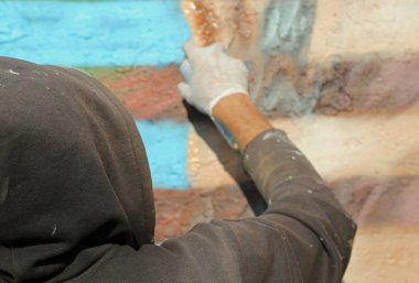 Paris, Fransa - 20 Ağustos 2017: Renkli grafiti ve beyaz eldiven ile bir duvar boyama sırasında sokak sanatçı