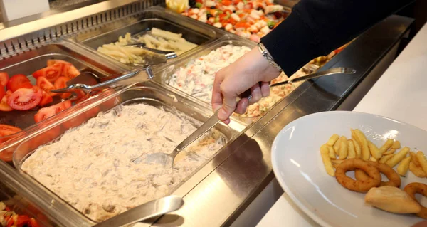 Inside a self service restaurant with many raw and cooked foods