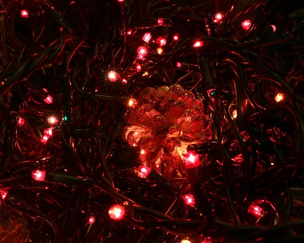 shimmering Christmas background with many LED lights and a golden pine cone to decorate the house