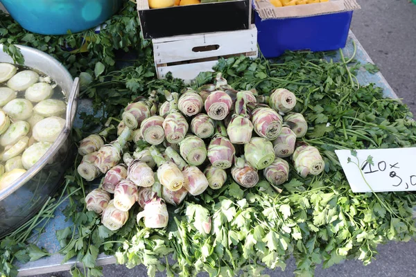 Artisjokken met peterselie voorbereiden op verkoop op de markt op de st — Stockfoto