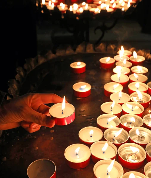 Velas com chama no lugar de adoração e uma mão de um menino — Fotografia de Stock