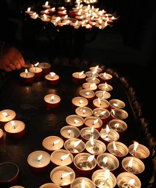 Kaarsen in de plaats van aanbidding door de oude vrouw die bidt — Stockfoto