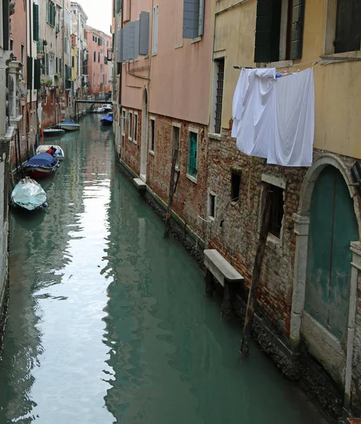 Cloths hanging over a waterway with boats in the island of Venic — Stock Photo, Image