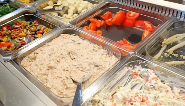 Muchas bandejas de alimentos cocidos y crudos en la cantina de la empresa — Foto de Stock