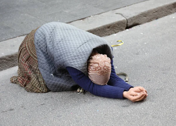 Anciana gitana mendigando por los transeúntes arrodillada con la mano —  Fotos de Stock