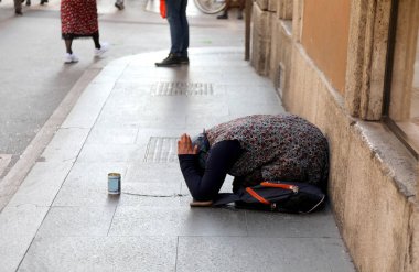 Çingene Kadın elini ile yere diz çökmüş sadaka isteyen