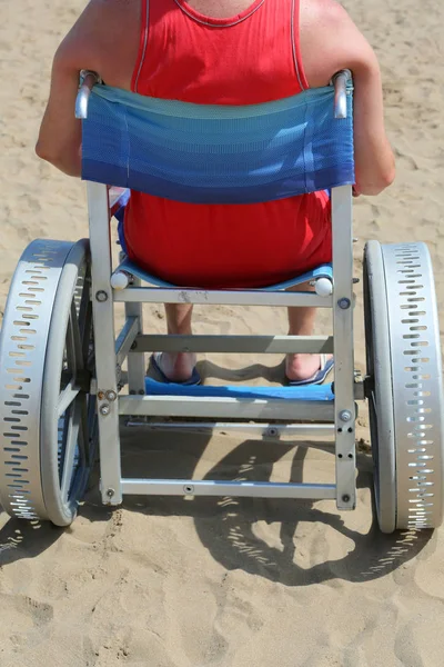 Joven en silla de ruedas en la playa de arena en verano — Foto de Stock