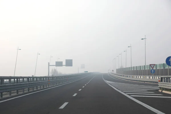 Туман очень опасен для автомобилистов на перекрестке шоссе зимой — стоковое фото