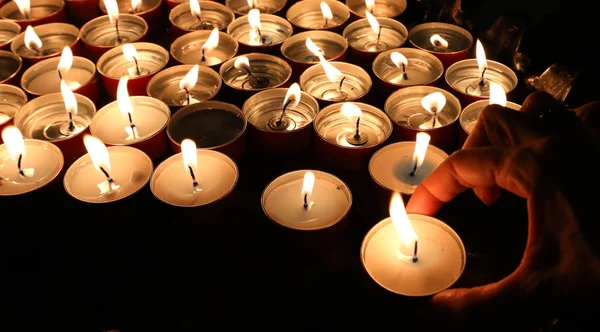 Mano od mujer y velas en el lugar de culto durante el rel —  Fotos de Stock