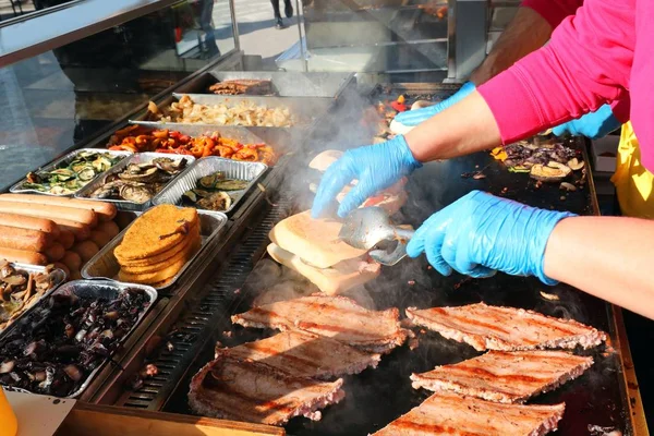 Chef com luvas e salsichas cozidas no prato quente — Fotografia de Stock