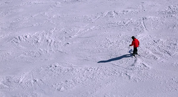 Esquiador en la ladera con nieve con ropa roja —  Fotos de Stock