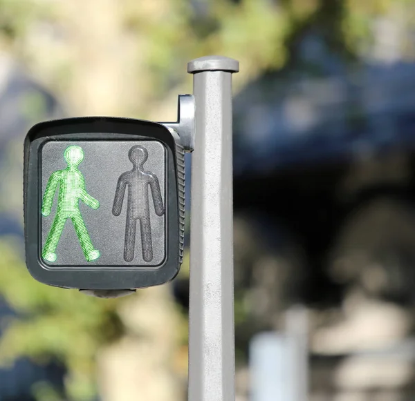 Luz de señal peatonal con símbolo de un hombre verde en la ciudad — Foto de Stock