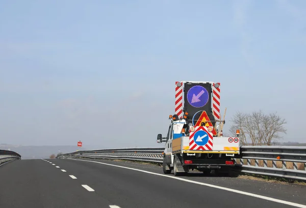 LKW mit großem Verkehrsschild mit Pfeil — Stockfoto