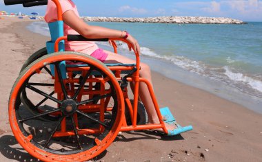 Özel turuncu tekerlekli sandalye üzerinde küçük kız