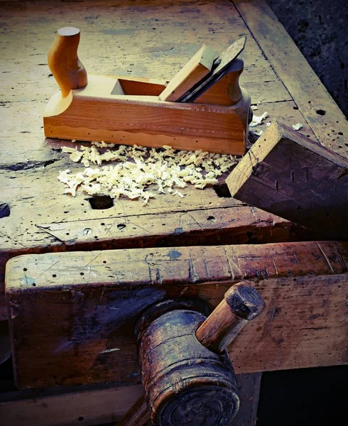 Afeitados de cepilladora y aserrín en el banco de trabajo de madera con tonelada vieja —  Fotos de Stock