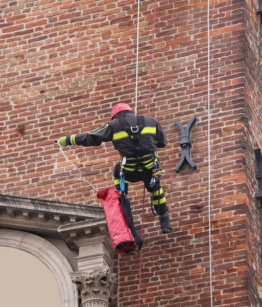 Bombeiro escalando com cordas em um prédio antigo para monitorar th — Fotografia de Stock