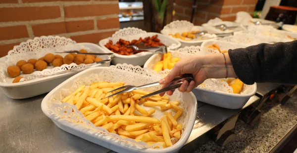 Papas fritas amarillas y más alimentos en la bandeja y la mano de un gi —  Fotos de Stock