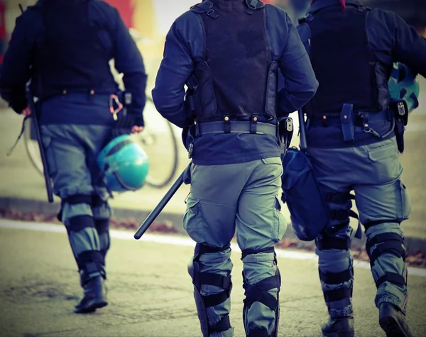 Tre poliziotti con giacca antiproiettile in uniforme antisommossa — Foto Stock