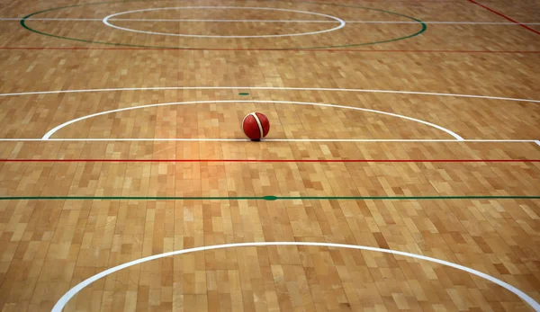 Баскетбольная площадка с деревянным паркетом и мячом — стоковое фото