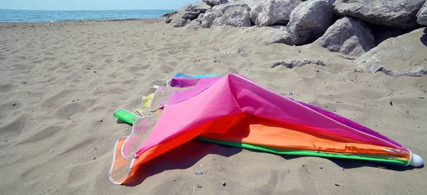 Złamany kolorowy parasol na plaży po burzy — Zdjęcie stockowe