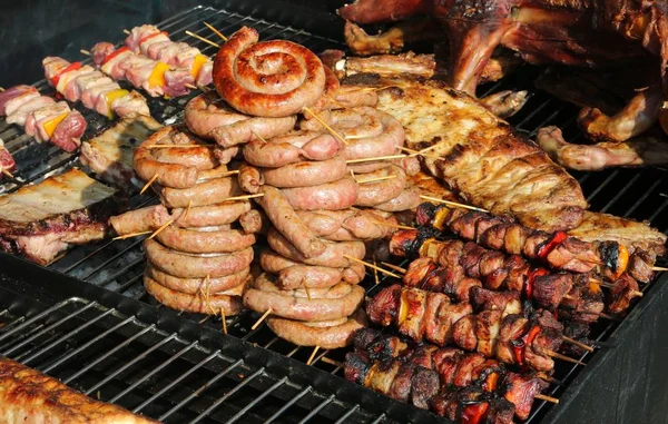 Enchidos e carne de porco assada em stand de comida de rua — Fotografia de Stock