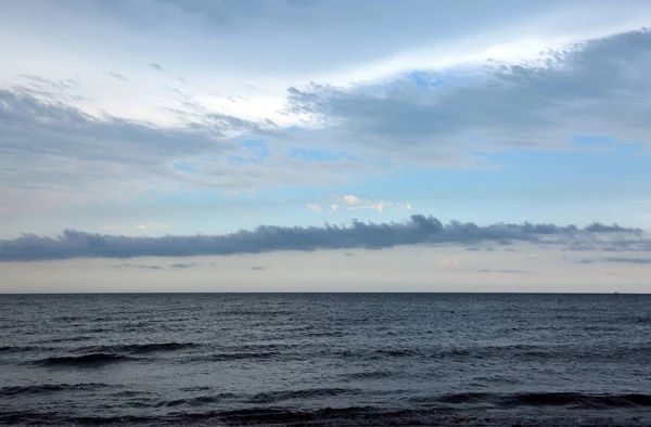 Landschaft mit Meer und weißen und dunklen Wolken — Stockfoto