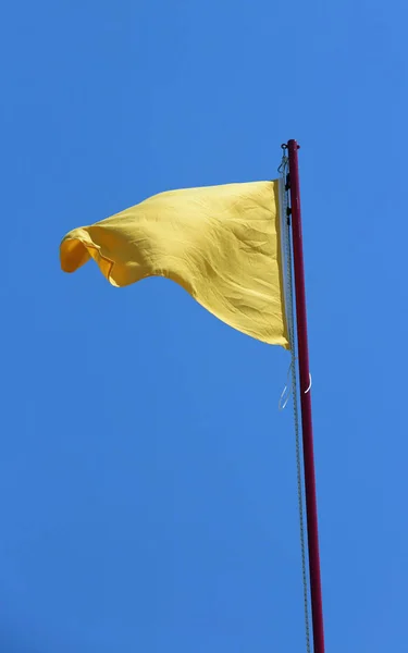 Duża żółta flaga symbol niebezpieczeństwa ostrzeżenia — Zdjęcie stockowe