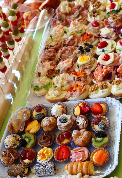 Buffet com bandejas cheias de doces e sanduíches — Fotografia de Stock