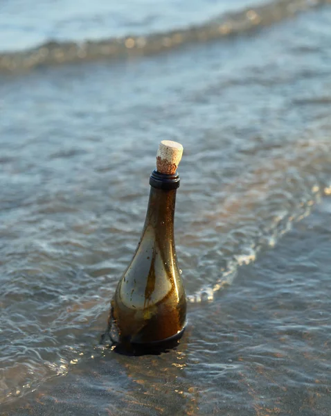 Glass bottle with cork cap on the beach — Stock Photo, Image