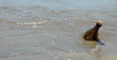 cam şişe içinde denizde yüzen bir mesaj ile