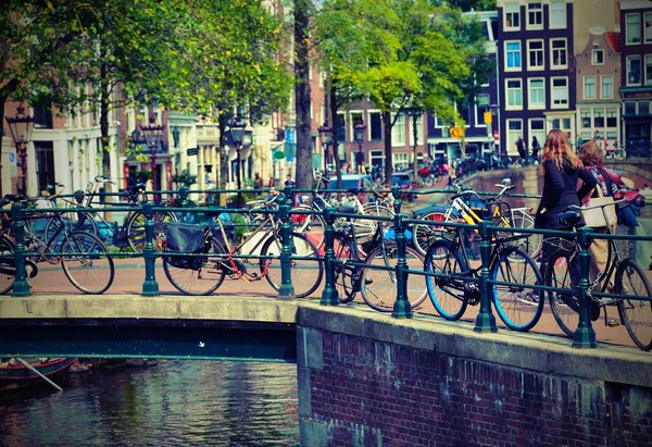 Bicycles over to the bridge in Amsterdam with old toned effect — Stock Photo, Image