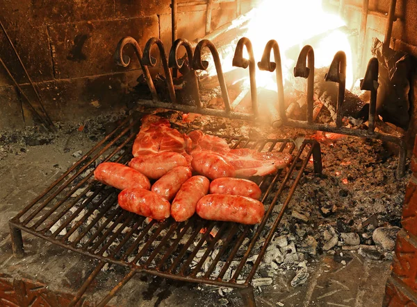 Salsichas e bife são cozidos na grelha — Fotografia de Stock