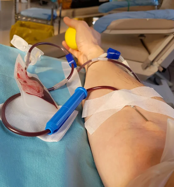 Armen av unga frivilliga under donation blod i sängen av en — Stockfoto