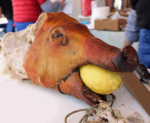 Roasted pork with a lemon in the mouth during a festival party — Stock Photo, Image