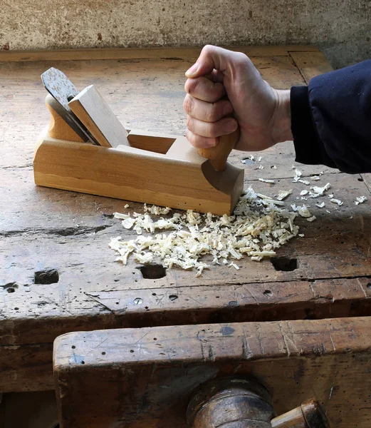 Mano del trabajador en el taller de carpintería con un plano — Foto de Stock