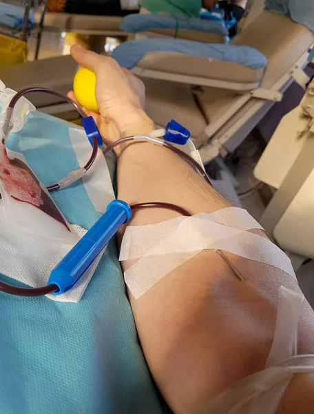 Mladý dobrovolník během darování krve v posteli medica — Stock fotografie