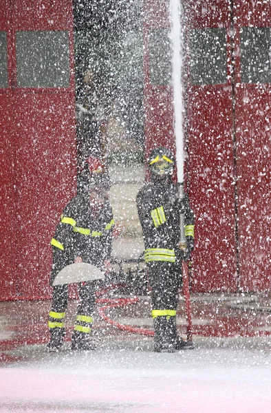 Pompiers lors d'un exercice dans la caserne de pompiers et la mousse — Photo