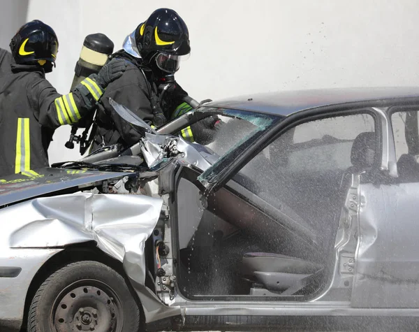 Пожежники під час пожежної боротьби з автомобілем після автомобільної аварії — стокове фото