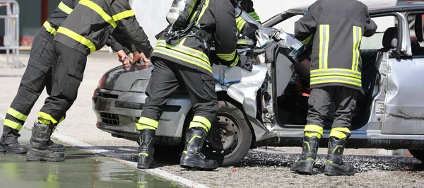 Brigada de bomberos durante la retirada del coche después del ácido de la carretera —  Fotos de Stock