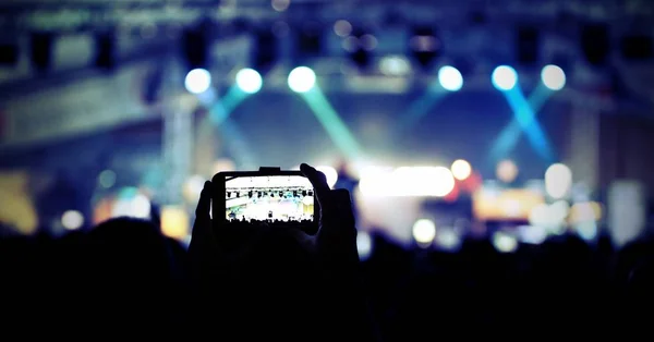 Toeschouwer fotografeert een beroemde zanger met een mobiele telefoon — Stockfoto