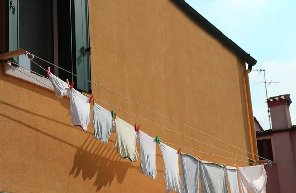 Ropa colgada para secar fuera de una casa naranja —  Fotos de Stock