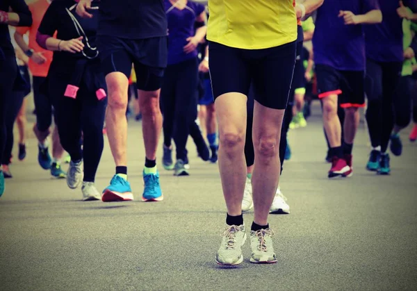 Pessoas com sapatos esportivos durante uma corrida com efeito tonificado velho — Fotografia de Stock