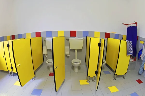 Cuarto de baño infantil con inodoros pequeños y puertas amarillas sin chi —  Fotos de Stock