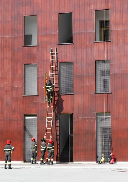 Räddnings övningar med stege och brandman i brandstationen — Stockfoto