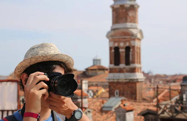 Jovem rapaz com chapéu leva picutres com sua câmera digital em Ven — Fotografia de Stock