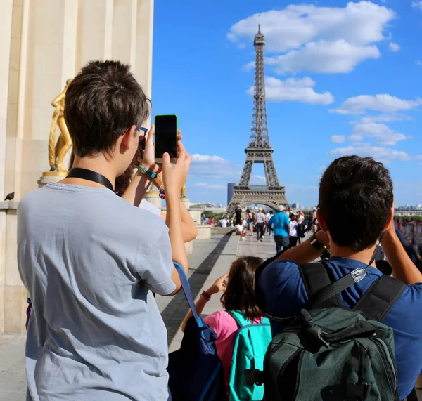 Молодые туристы фотографируют Эйфелеву башню в Париже — стоковое фото
